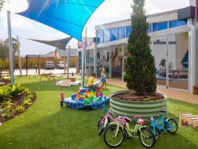Outdoor childcare centre with modern play equipment, open play areas, and a safe, well-designed environment for children. Overlaid promotional text from Mollard Property Group highlights the importance of being “lease-ready” in a competitive childcare market, emphasising preparation, strong branding, clear commercial positioning, and fast decision-making to secure premium sites. Includes reference to a case study where Little World Academy secured a lease in 10 days due to strong preparation.