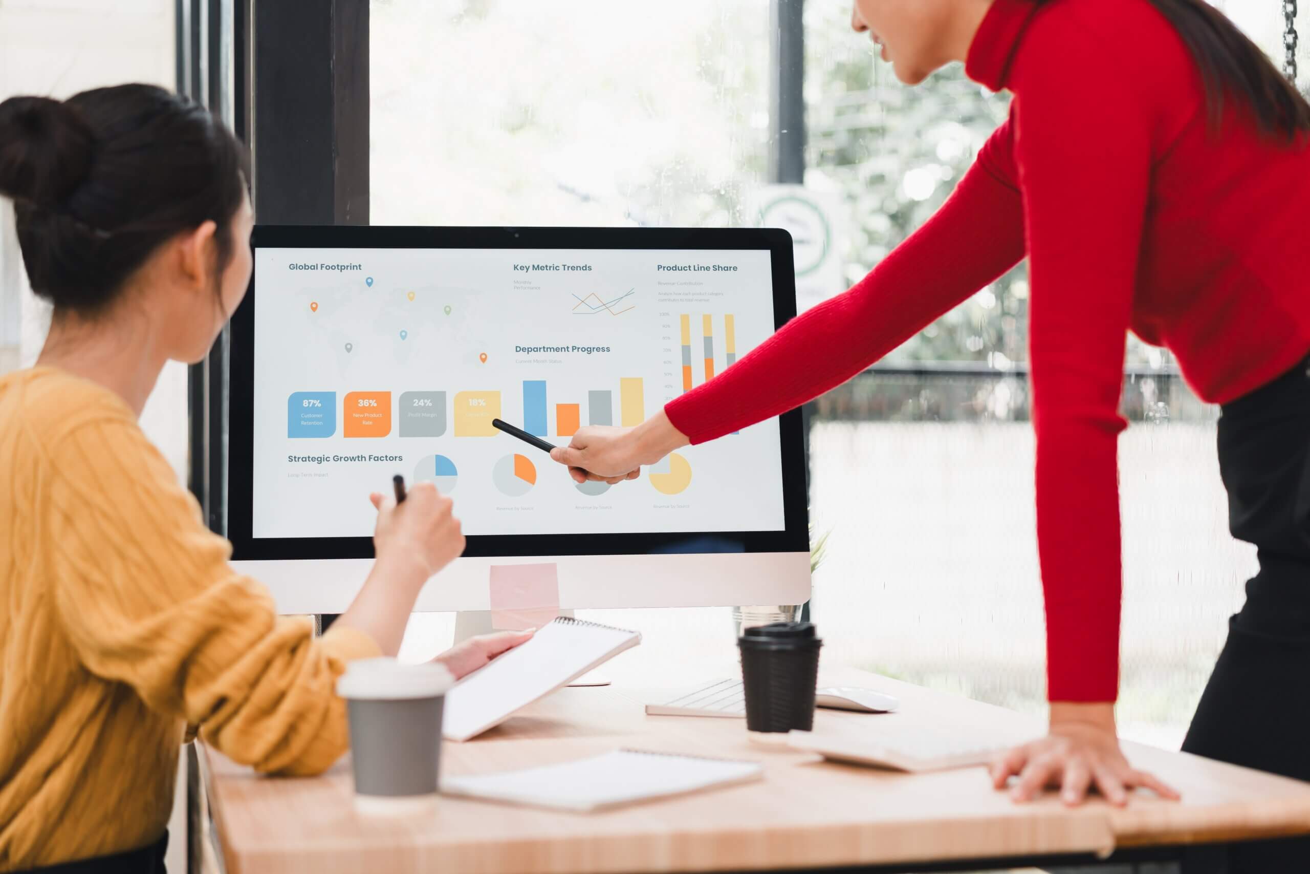 A project administrator reviewing project analytics and reporting dashboards with a client