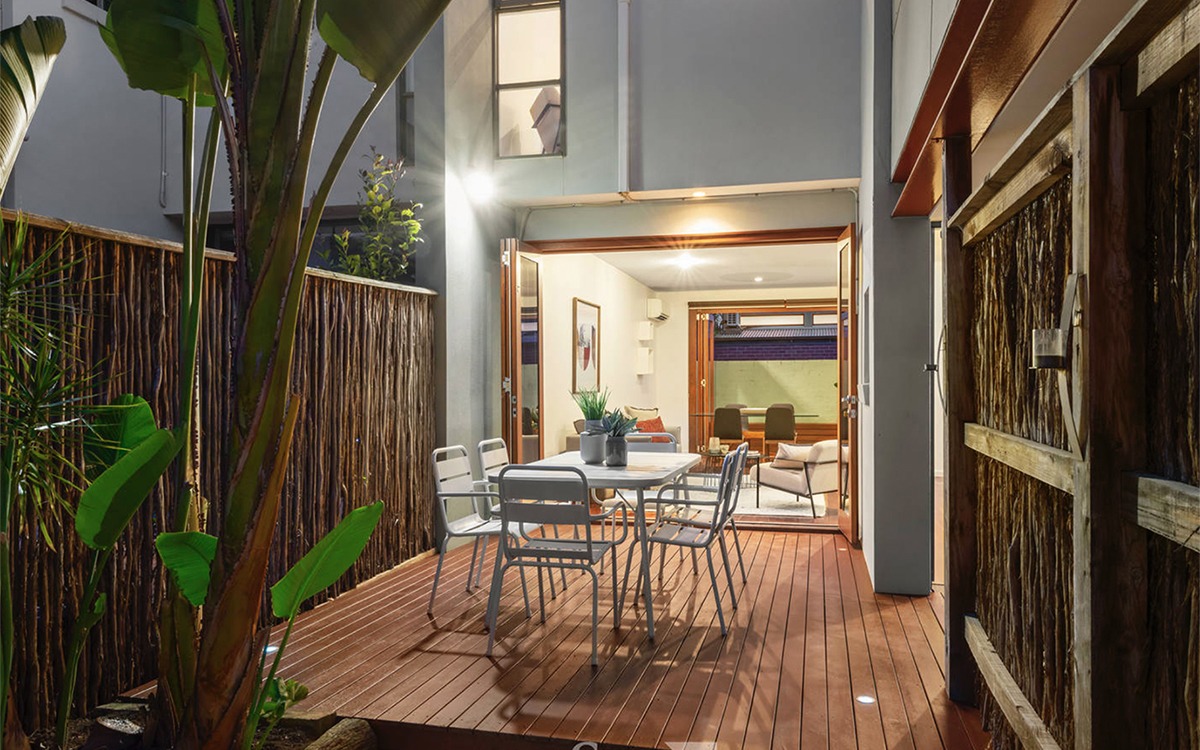 Timber entertaining deck with outdoor dining area opening directly into the home's living spaces.
