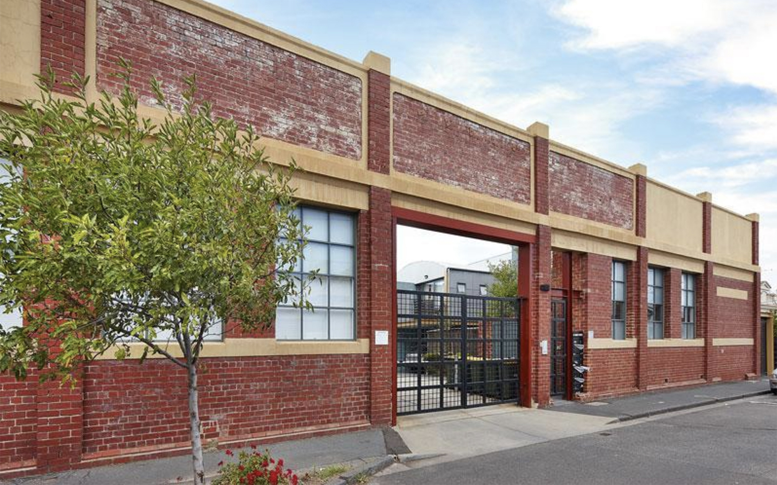Restored heritage warehouse façade with secure gated entrance and original industrial brickwork.