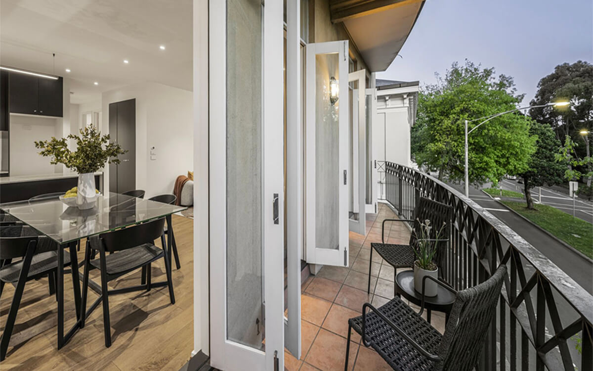 Apartment balcony overlooking a tree-lined street from the Albert Street residential development in East Melbourne.