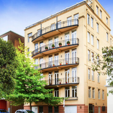 Residential apartment building on Albert Street, East Melbourne with balconies, heritage detailing and landscaped streetscape.