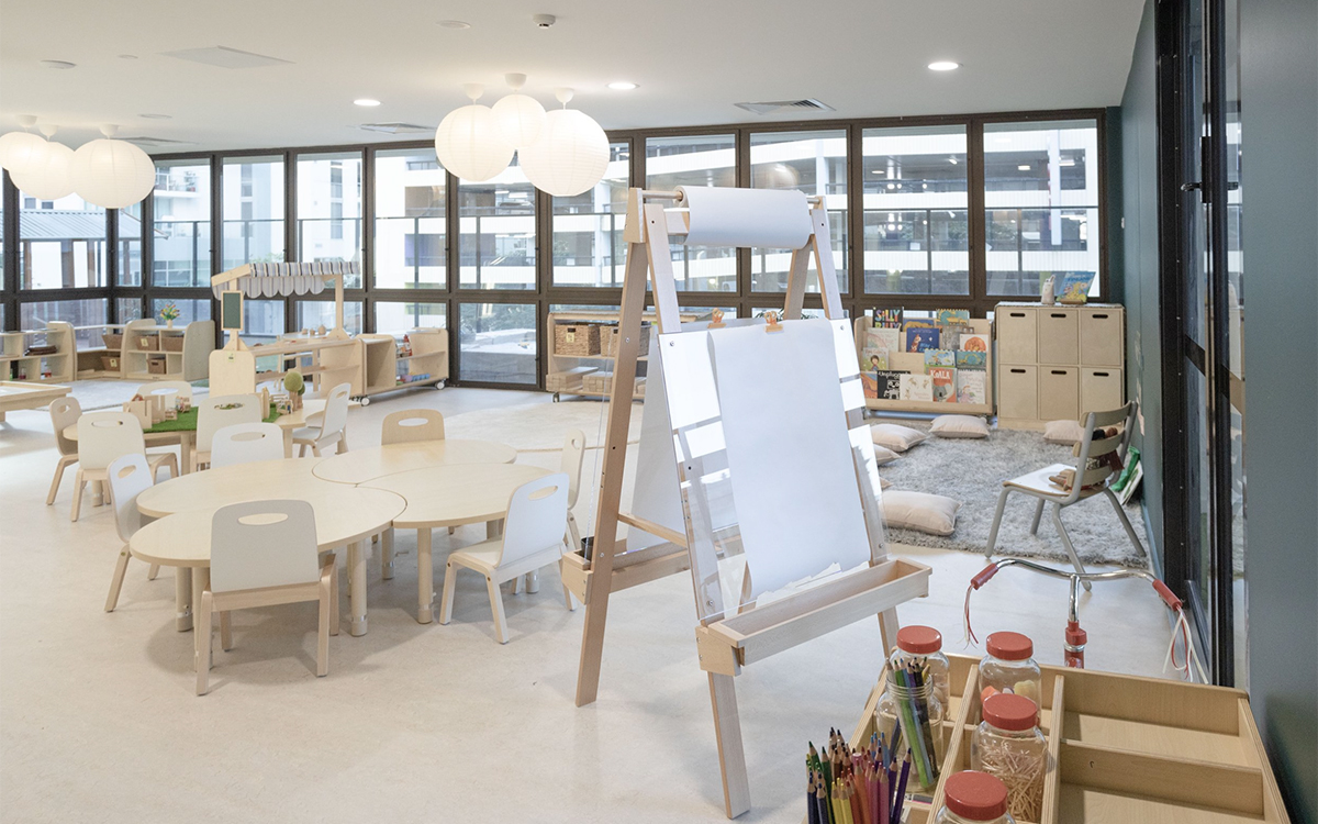 Early learning classroom at HEI Schools with children's tables, art station and reading corner.