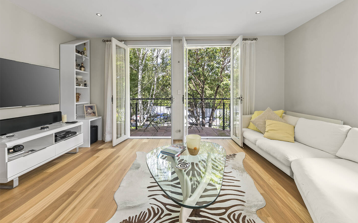 Bright open-plan living room with timber flooring, balcony access and modern furnishings at Edgewood on Lennox in Richmond Hill.