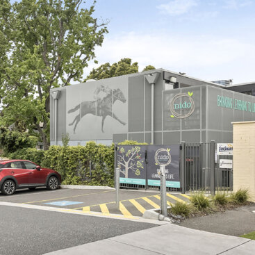 Street view of the childcare centre entrance with parking area, signage and surrounding landscaping.
