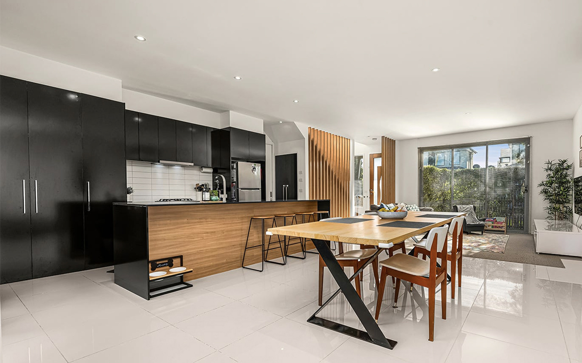 Open-plan kitchen, dining and living area with island bench, dining table and seating area.