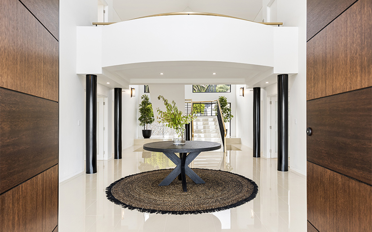 Double-height entrance foyer with sweeping staircase, polished floors and contemporary finishes.