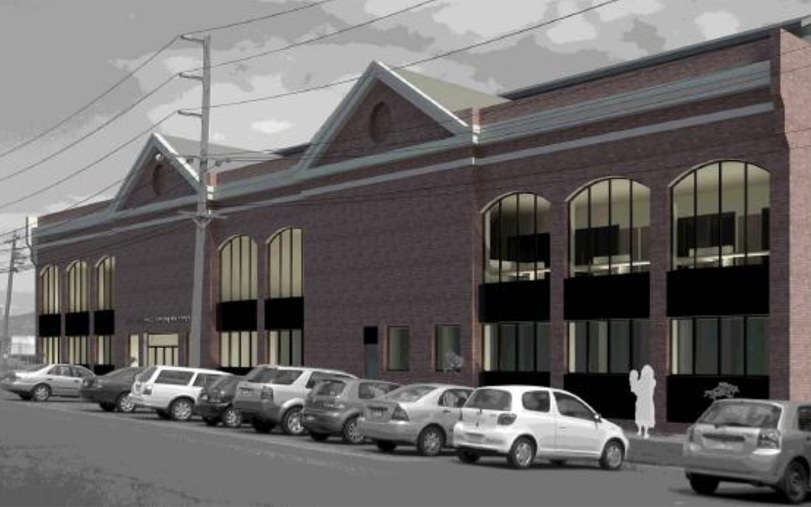 Street view of a commercial building with arched windows, gabled roof forms and on-street parking in South Melbourne.