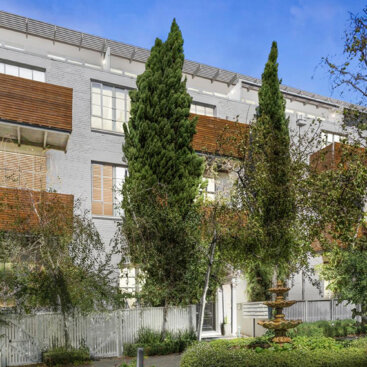 Landscaped communal gardens at Tullo Place featuring apartment buildings, mature trees and central fountain.