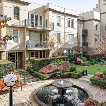 Landscaped central courtyard with fountain surrounded by apartment buildings and gardens.