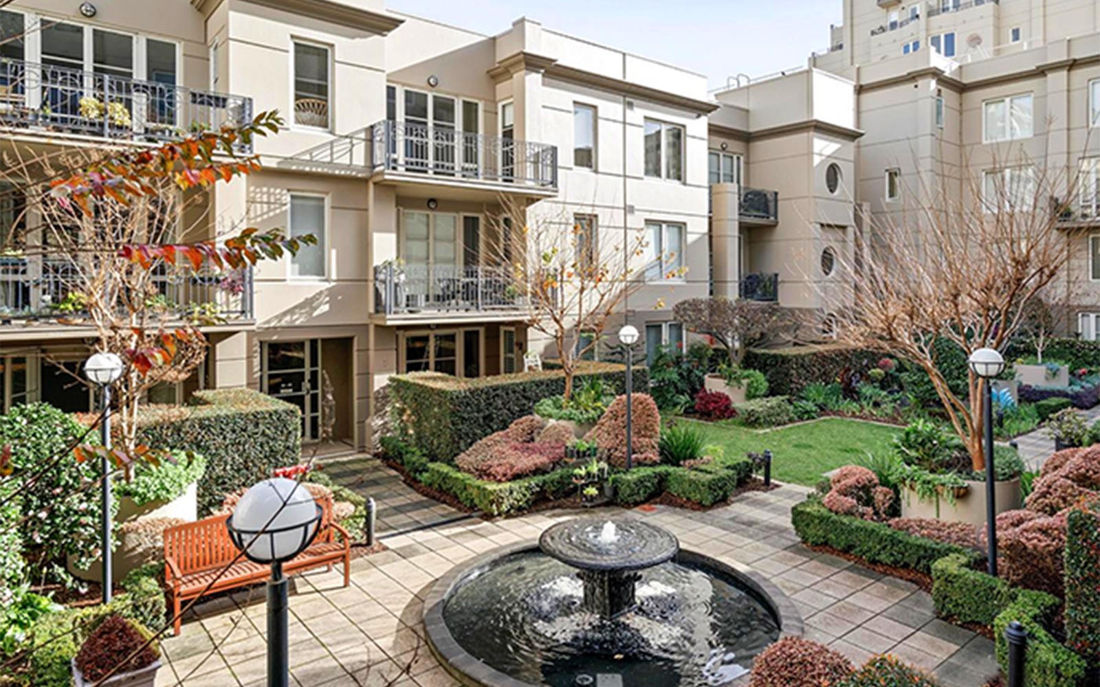 Landscaped central courtyard with fountain surrounded by apartment buildings and gardens.